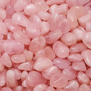 Soft pink Rose Quartz tumbled stones on a white background.