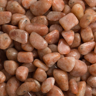 A sparkling golden-orange Sunstone crystal radiating light.