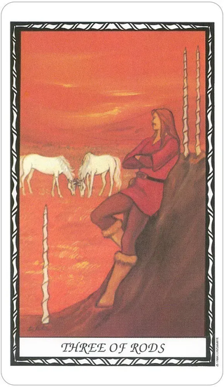 Tarot card titled 'Three of Rods' with a person in red clothing sitting on a rock, two white horses, and a sunset sky.